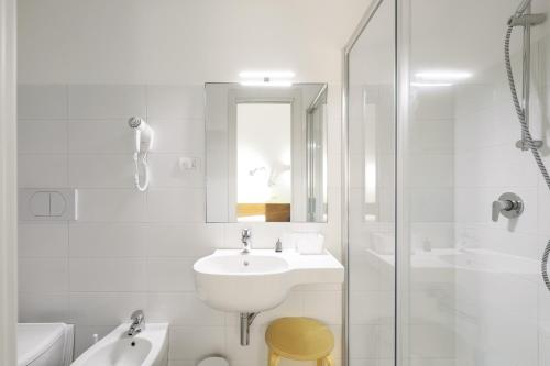 a white bathroom with a sink and a shower at bellaMI in Milan