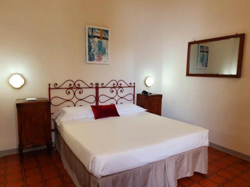 a bedroom with a white bed with a red pillow at Hotel Annalena in Florence