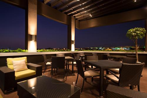 a patio with tables and chairs at night at Wyndham Garden San Jose Escazu, Costa Rica in San José