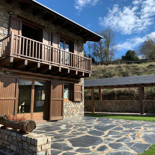 a house with a balcony and a stone patio at Can Marc de Pi, Bellver de Cerdanya in Pi