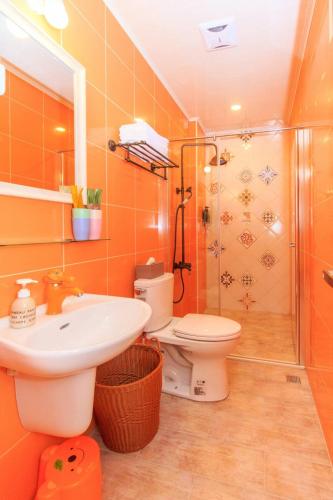 a bathroom with a toilet and a sink and a shower at 新斑鳩小鎮親子民宿 10-28人可來電包棟 in Wujie