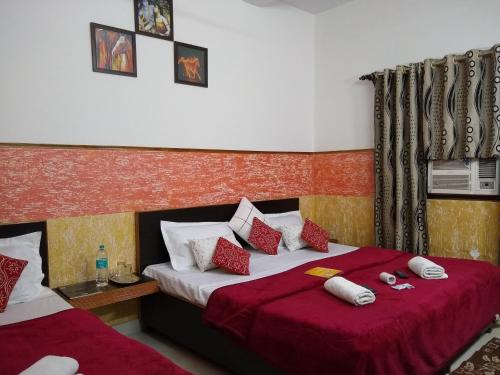 - une chambre avec 2 lits dotés d'oreillers rouges et blancs dans l'établissement Agra Paying Guest House, à Agra