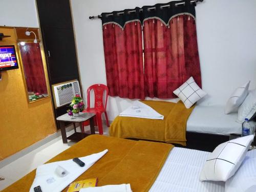 a hotel room with two beds and a red curtain at Agra Paying Guest House & Home Stay in Agra