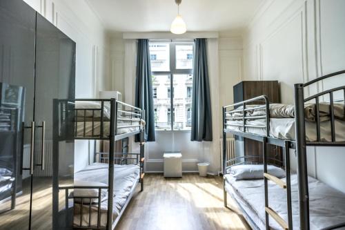 a room with three bunk beds and a window at Sandeman-Allen Hostel (Bayswater) in London