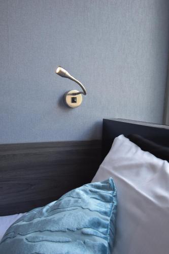 a lamp on a wall next to a bed at Hotel Hermitage Amsterdam in Amsterdam