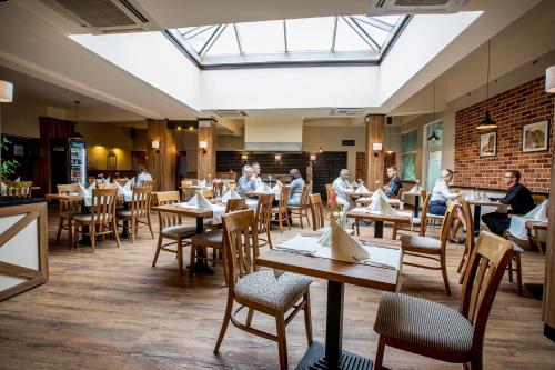a restaurant with people sitting at tables in a room at Hotel Diament Zabrze - Gliwice in Zabrze
