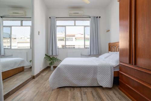 1 dormitorio con 2 camas y ventana en Apartamento Copacabana RJ, en Río de Janeiro