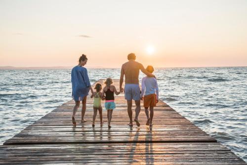 a family walking on a pier over the water at Falkensteiner Premium Mobile Homes and Camping Zadar in Zadar