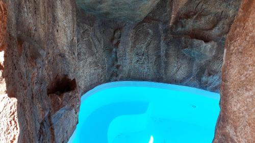 a cave with a blue pool in a stone wall at Casa Almeida in Vimieiro