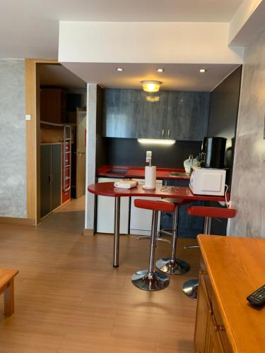 a kitchen with a table and red stools at Confortable Lake Placid in Pas de la Casa