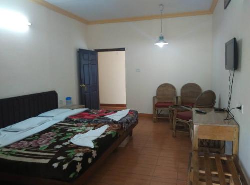 Cette chambre comprend deux lits, une table et des chaises. dans l'établissement Poopada, à Munnar