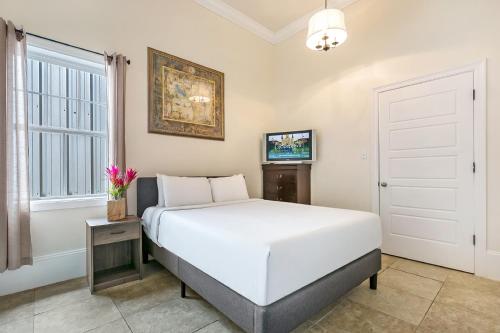 Un dormitorio con una cama blanca y una ventana. en Spacious 4BR Condo on Carondelet Near All Hot Spo, en Nueva Orleans