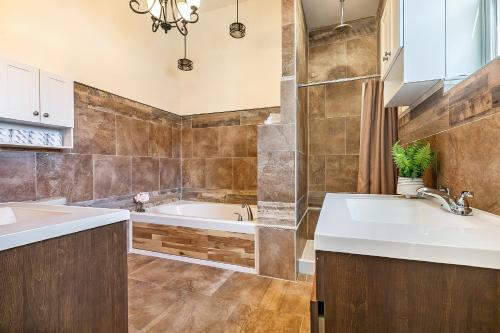 Un baño con dos lavabos y una bañera. en Spacious 4BR Condo on Carondelet Near All Hot Spo, en Nueva Orleans