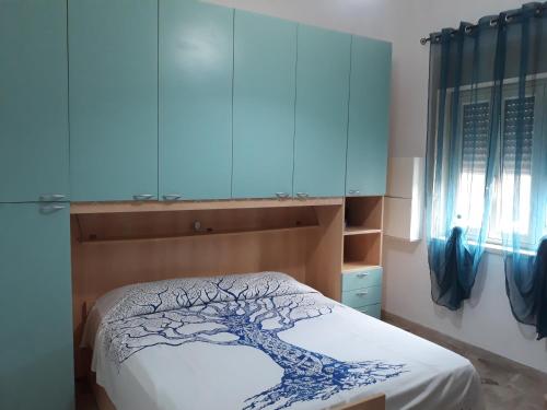 Un dormitorio con una cama con un árbol. en Vacanzasicilia, en Porto Empedocle