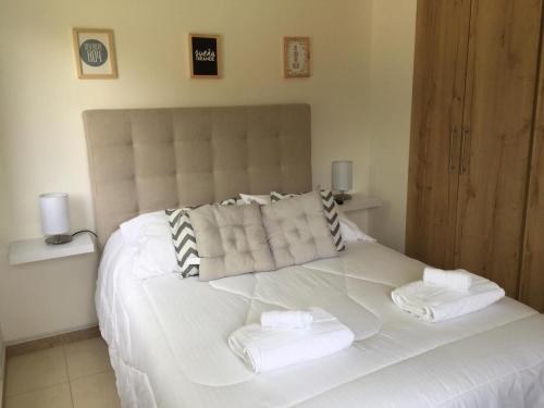a bedroom with a white bed with towels on it at Quindio - Apartasol 207 in La Tebaida