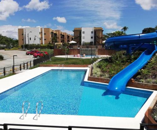 a swimming pool with a blue water slide at Quindio - Apartasol 207 in La Tebaida