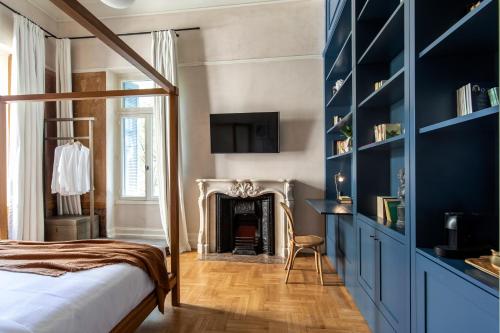 een slaapkamer met een bed en een open haard bij Monsieur Didot in Athene