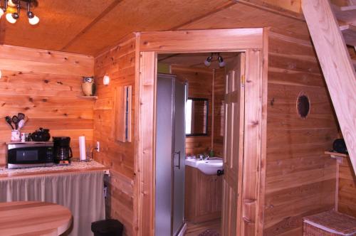 a bathroom in a wooden cabin with a sink at Les Cabanes du Trappeur in Wentworth-Nord
