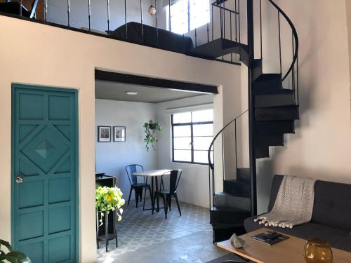 a living room with a green door and a staircase at Casa Nican by Barrio Mexico in Guadalajara