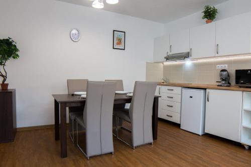 a kitchen with a table and chairs in a room at Mecset Apartman in Eger