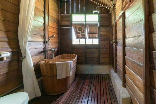 a wooden bathroom with a tub and a toilet at tanabendang banglos in Pantai Cenang