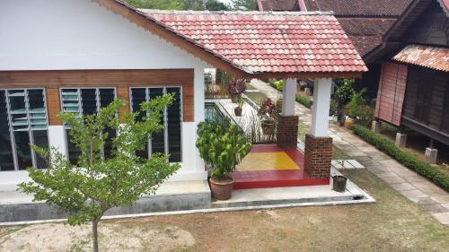 a small house with a red roof at tanabendang banglos in Pantai Cenang