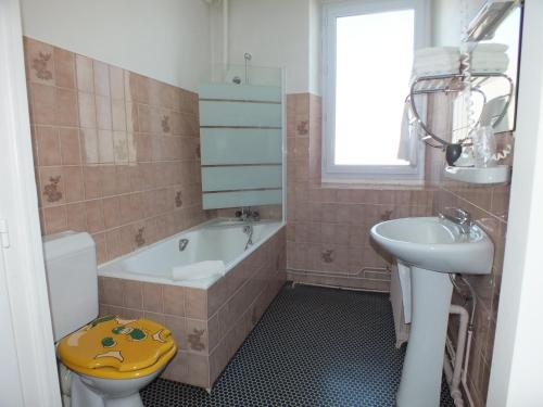 een badkamer met een bad, een wastafel en een toilet bij Hotel La Prairie in Méaudre