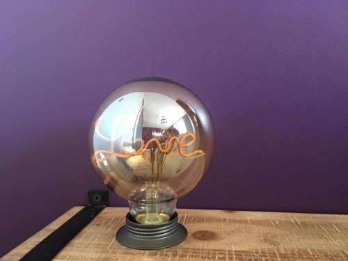 een glazen bol lamp bovenop een tafel bij L’Edaines in Bagnoles de l'Orne