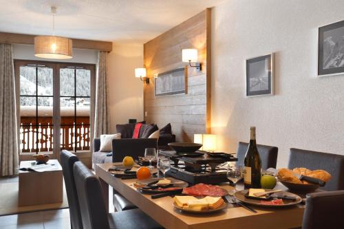 - une salle à manger avec une table et une bouteille de vin dans l'établissement Résidence Néméa Le Grand Ermitage, à Châtel