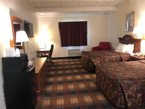 Un pat sau paturi într-o cameră la Red Carpet Inn Syracuse Airport