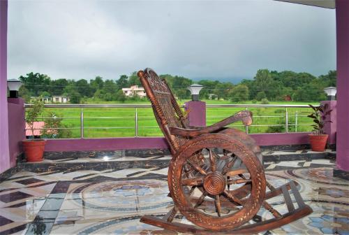 a wooden rocking chair sitting on top of a porch at BillingVista Guest House Bir in Bīr