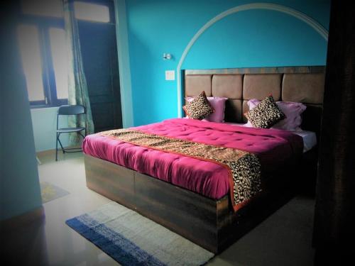 a bedroom with a large bed with a red bedspread at BillingVista Guest House Bir in Bīr