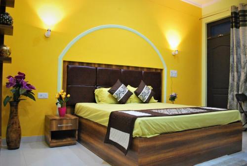 a bedroom with a large bed with yellow walls at BillingVista Guest House Bir in Bīr