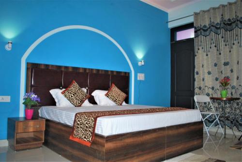 a bedroom with a large bed with blue walls at BillingVista Guest House Bir in Bīr