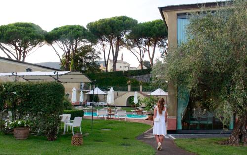 a woman in a white dress walking through a garden at Villa Agnese in Sestri Levante