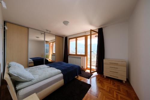 a bedroom with a bed and a large window at Awesome Panorama Penthouse - free Parking and balcony in Sarajevo