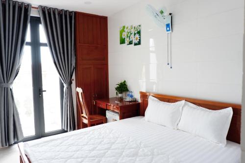 a bedroom with a bed and a desk and a window at Thy Hung legacy hotel in Tuy Hoa