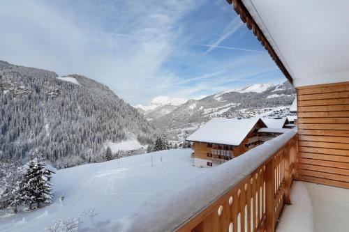 a snow covered balcony with a view of a mountain at Résidence Néméa Le Grand Lodge in Châtel