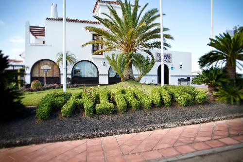 un edificio con un montón de plantas delante de él en Fairways Club, en San Miguel de Abona