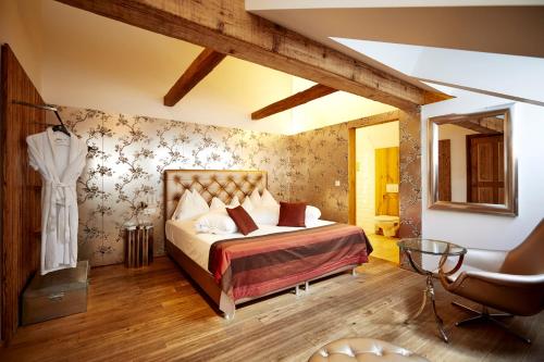 sypialnia z łóżkiem i krzesłem w obiekcie Hotel Landhaus Moserhof w mieście Gumpoldskirchen
