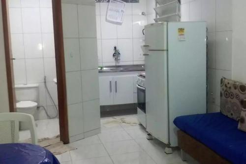 uma pequena cozinha com um frigorífico e um lavatório em Sonhos de sereia em Ponta da Fruta