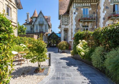 a walkway through a courtyard of a house at Villa Augeval Hôtel de charme & Spa in Deauville