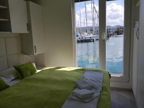 a bedroom with a large window looking out at the water at Matorin Floatinghouses in Portorož