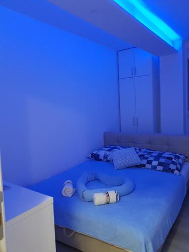 a room with a bed with blue lights on it at Apartment GEA 18 in Novi Sad