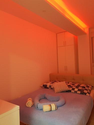 a room with a bed with orange walls at Apartment GEA 18 in Novi Sad
