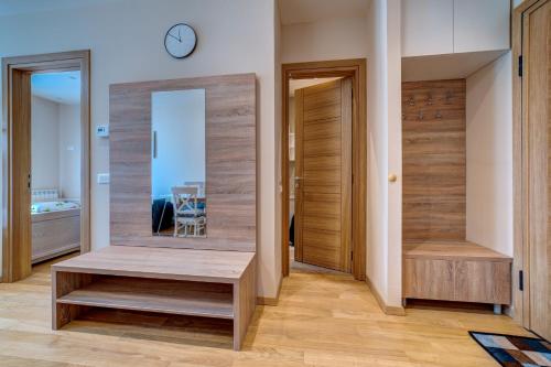 ein Flur mit einer Holztür und einem Spiegel in der Unterkunft Hill Spa in Zlatibor