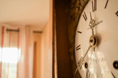 un reloj está colgando de una pared en Ferme d'Andree, en Chaudenay-le-Château