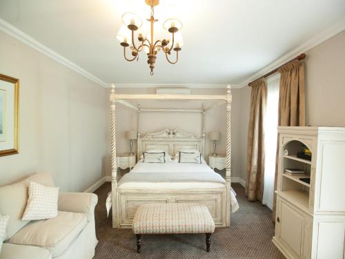 a bedroom with a white bed and a chandelier at Old House Lodge in Beaufort West
