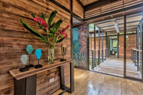 a room with wooden walls and a vase with flowers on a table at La Shamana - Ecological Concept in Jungle in Cahuita