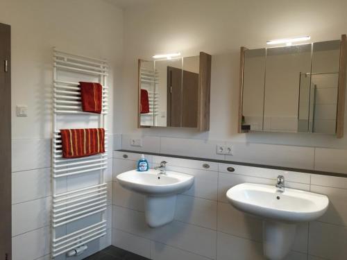 La salle de bains est pourvue de 2 lavabos et de 2 miroirs. dans l'établissement Easy Stay Home, à Oberboihingen